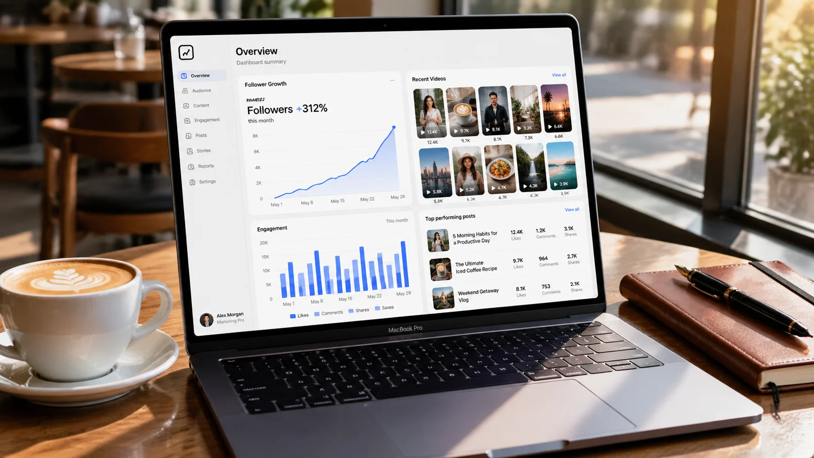 MacBook on a cafe table showing a marketing analytics dashboard with rising follower count and captioned video thumbnails
